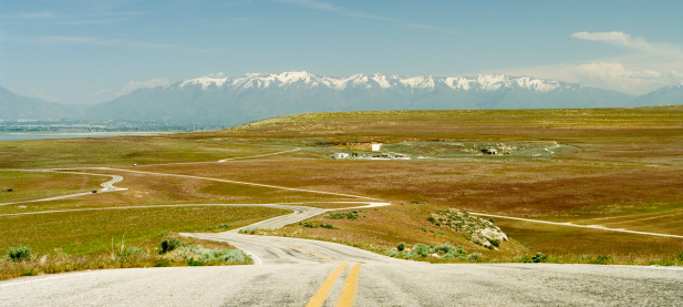 Empty road in Utah. Rocky Mountains at the distance