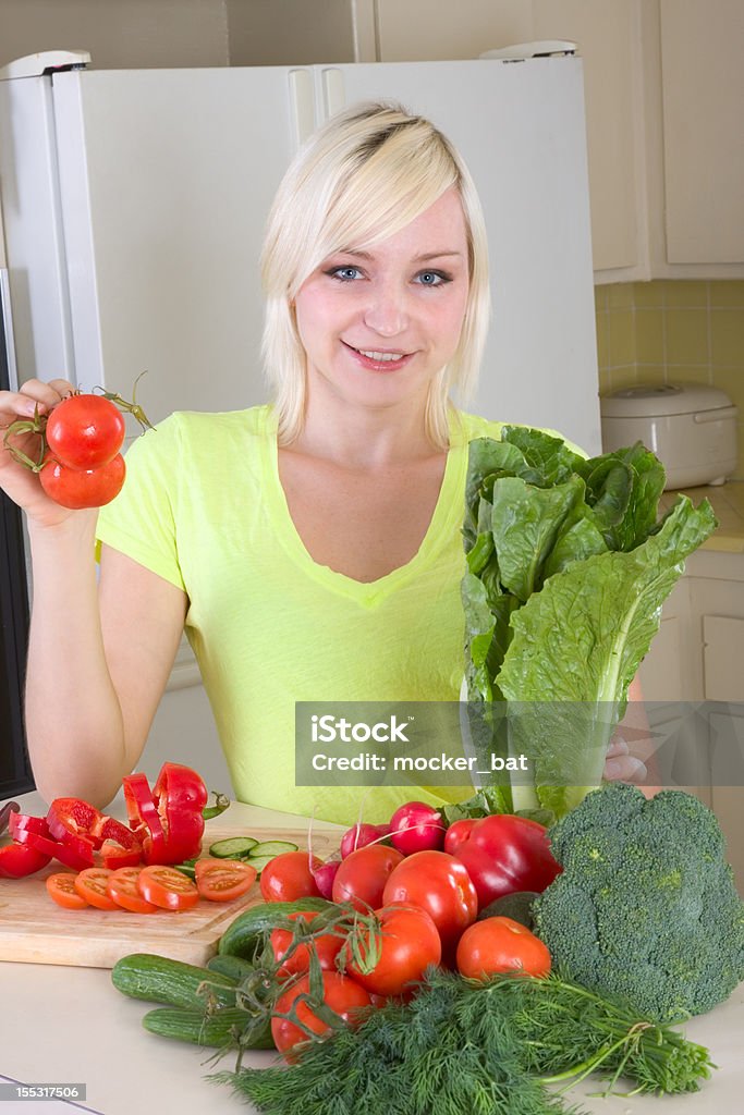 Jeune femme blonde avec des légumes dans la cuisine - Photo de 25-29 ans libre de droits