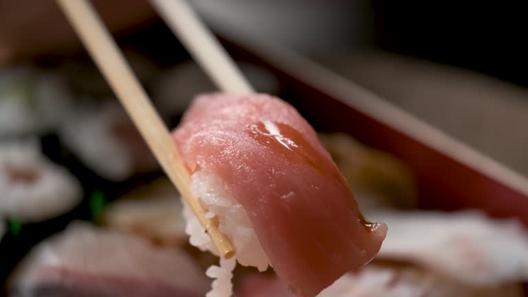 Adding soy sauce on tuna nigiri.