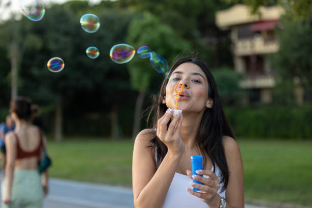 istock Young woman is  blowing bubbles on the outside. 1553193391
