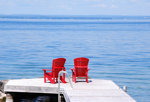 Two red chairs on a wooden dock