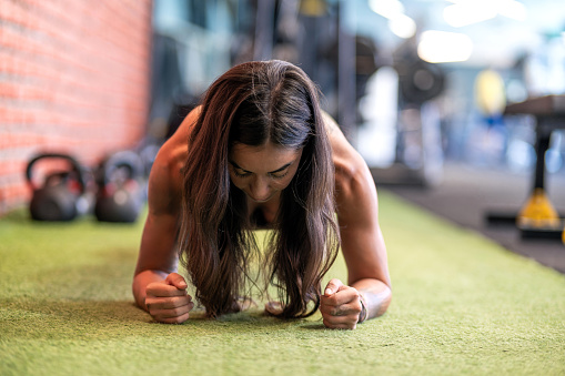 Muscular woman doing plank exercise