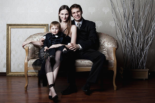happy family portrait of happy family sitting on the couch formal family portraits stock pictures, royalty-free photos & images