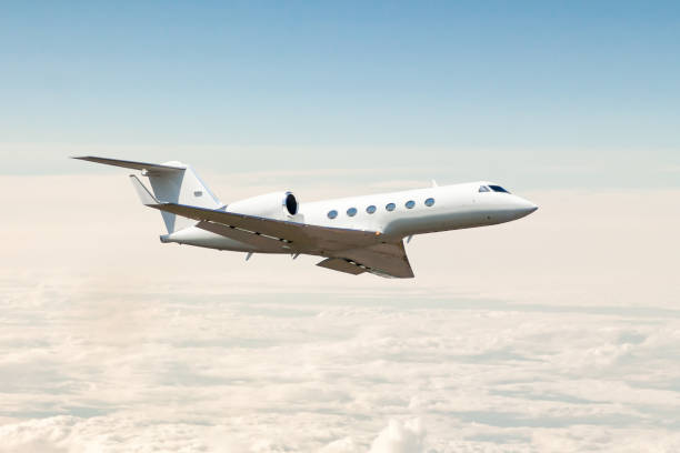 white luxury private jet flying in the air above the clouds - corporate jet imagens e fotografias de stock