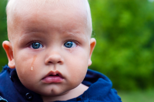 portrait of crying boy, visible tears on face  