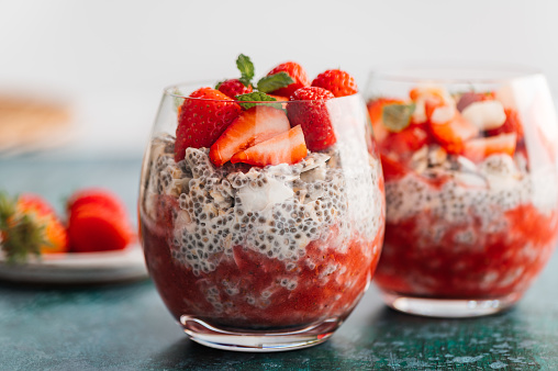 Healthy chia pudding in a glass with fresh strawberries made from almond milk and berry juice. Perfect breakfast for healthy start of the day