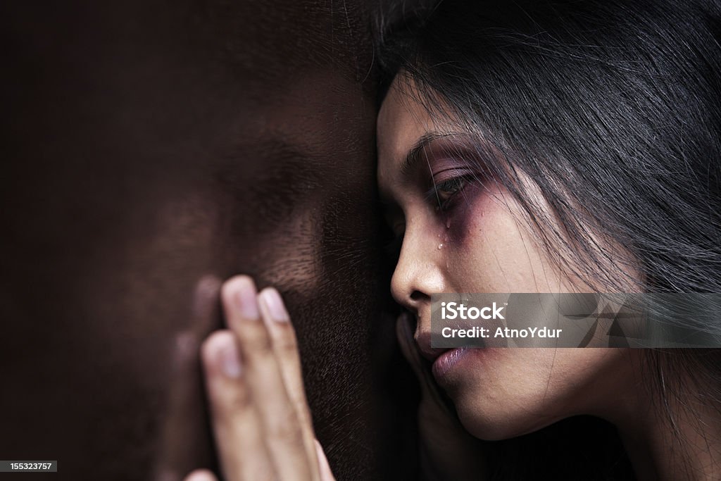 Injured woman leaning sadly on wooden wall Injured woman leaning sadly on wooden wall, concept for domestic violence   Domestic Violence Stock Photo
