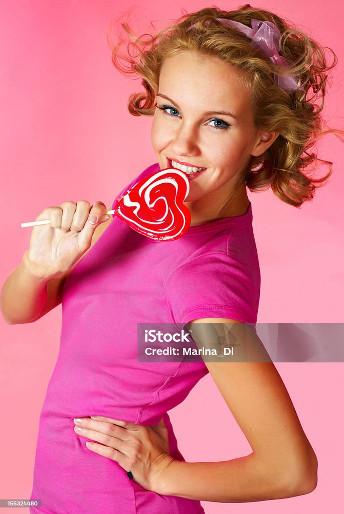 candy girl young happy woman with heart shaped lollipop Adult Stock Photo