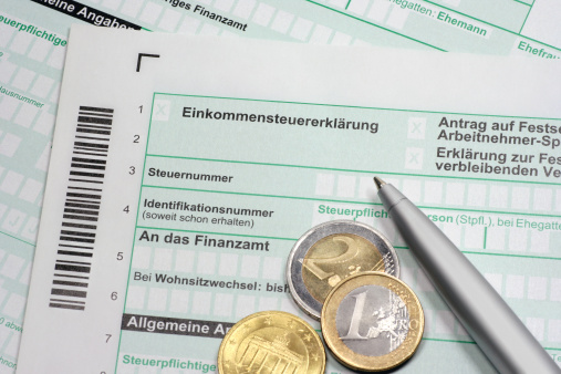 German tax form âEinkommensteuererklÃ¤rungâ with euro coins and pen