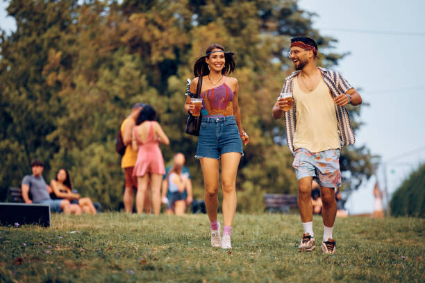 Full length of happy couple on open air music festival. Young happy couple enjoying in summer day while going to a music concert. Copy space. festival goer stock pictures, royalty-free photos & images
