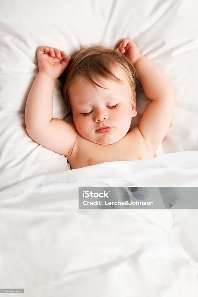 Baby sleeping Baby sleeping in white bed 12-17 Months Stock Photo
