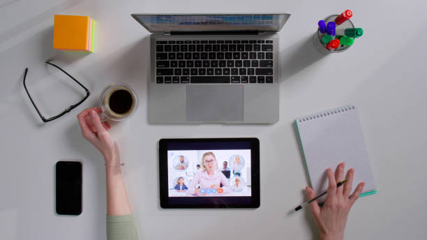 istock Top view of female student watch webinar on digital tablet and open copybook 1553255530