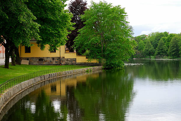 houses on the bank of a river. - eskilstuna bildbanksfoton och bilder