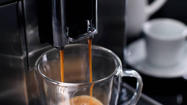 istock Close up of coffee pouring from coffee machine in a cup 1553262059