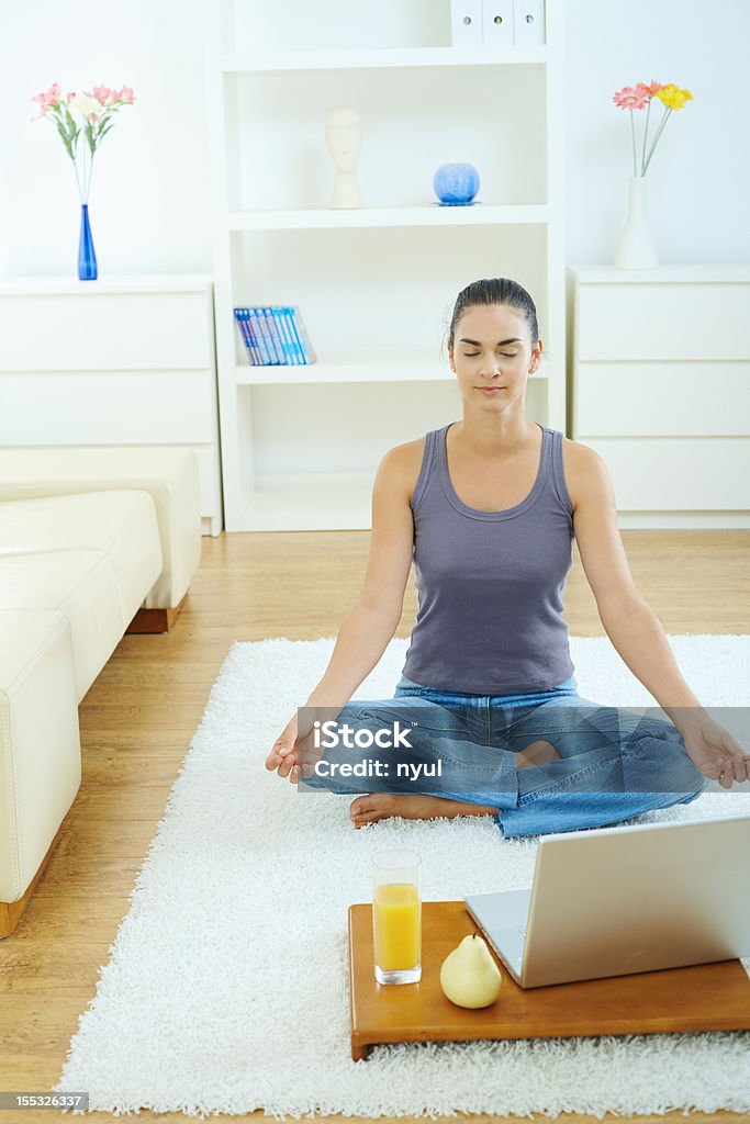 Meditation "Beautiful woman sitting cross-legged on the floor at home, meditating. Click here for more ""People at Home"" images:    " Healthy Lifestyle Stock Photo