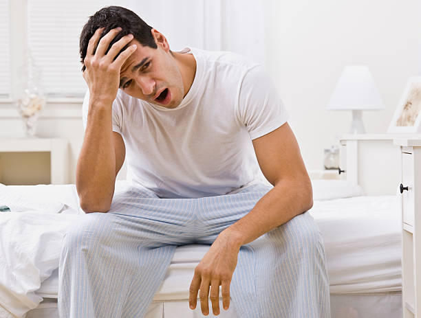 istock Attractive Man Sitting on His Bed Yawning 155326728