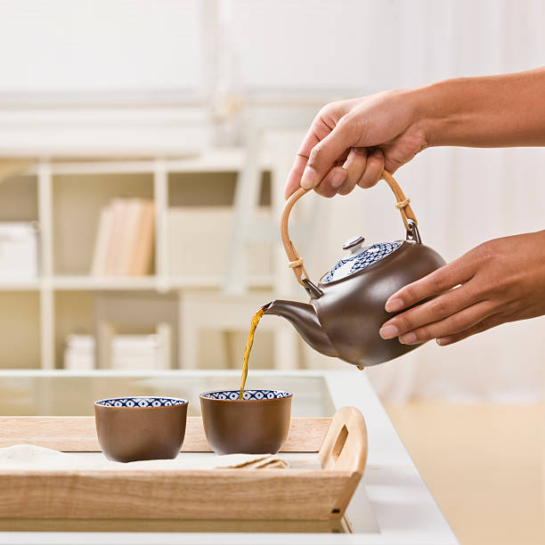 istock Close-up of Hands Pouring Tea 155328378
