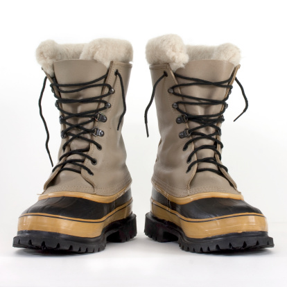 a pair of heavy snow boots on white background, low angle perspective  