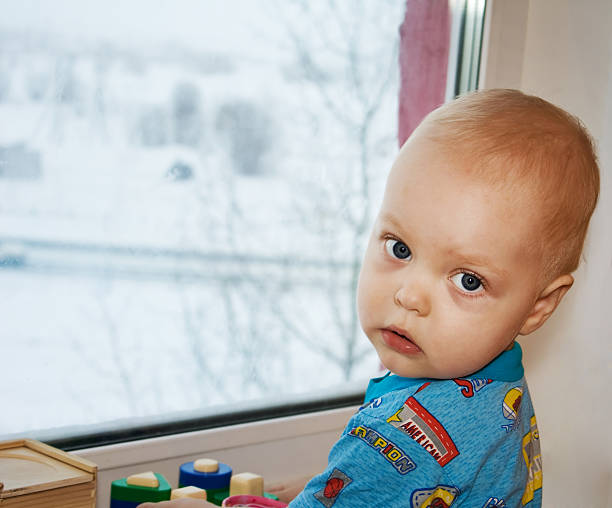 boy at a window stock photo