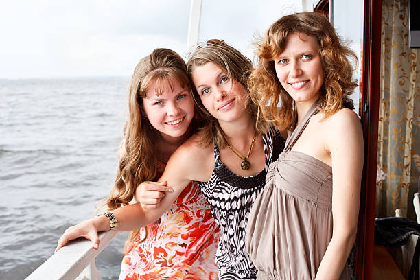 istock Three beauty young women standing together on deck of ship 155332046