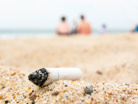 Cigarette butt on a beach, pollutionconcept