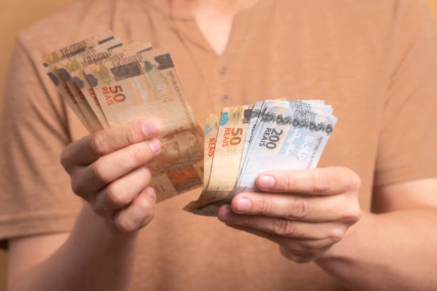 istock anonymous man showing cash from Brazil 1553325985