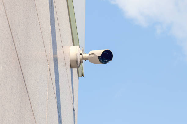 istock Small white CCTV camera camera on the wall of building 1553355348