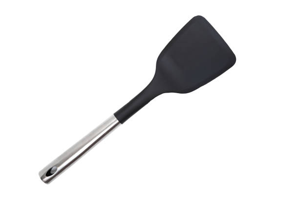 Close-up of a black plastic kitchen spatula with stainless steel handle on a white background
