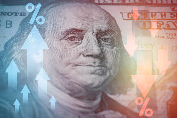 istock Closeup Benjamin Franklin face on USD banknote with percentage and up down arrow for currency exchange and global trade forex concept. 1553377334