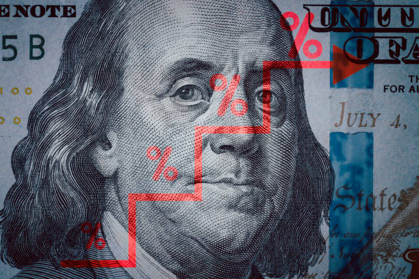 istock Closeup Benjamin Franklin face on USD banknote with stock market chart graph for currency exchange and global trade forex concept. 1553377909