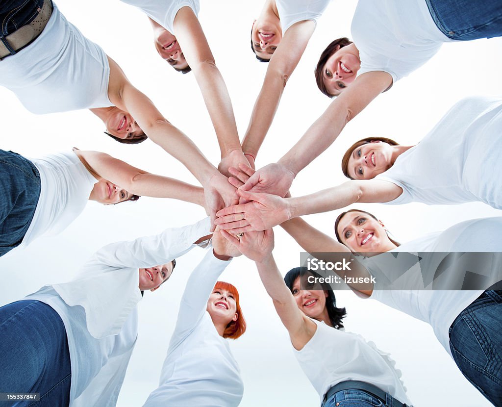 Women's team Teamwork concept. Group of women joining hands. Low angle view, white background. Women's Rights Stock Photo