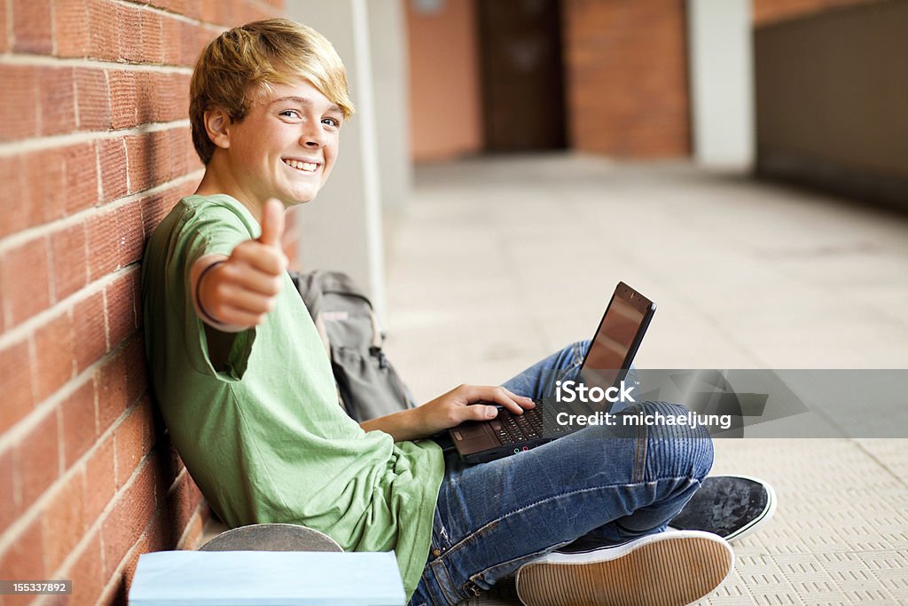 teenage student giving thumb up teenage student giving thumb up while using laptop Thumbs Up Stock Photo