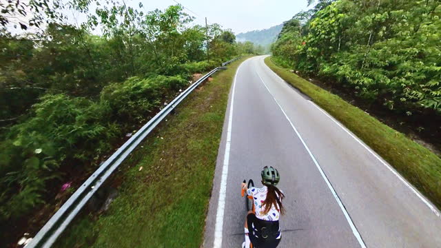 Asian Chinese female cyclist cycling in rural scene weekend morning