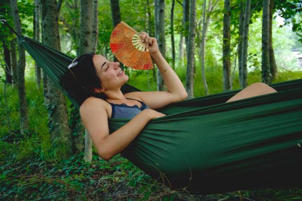 istock Girl in a hammock with a fan 1553396650