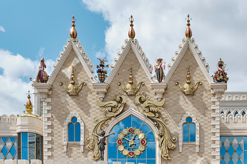 Kazan, Russia - June 8, 2023: Facade of building of State Puppet Theater Ekiyat, built in 2012, chief architect S.Mamleeva. Close-up. Fairy castle, colored sculpture toys, Little Prince, huge clock.