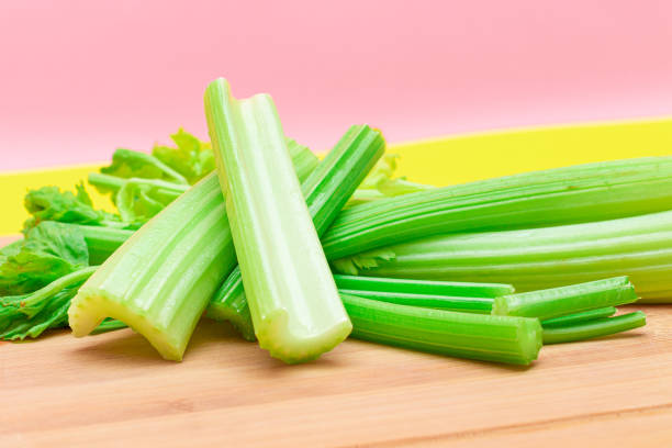 istock Fresh Celery Stem and Chopped Celery Sticks on Wooden Cutting Board 1553411198