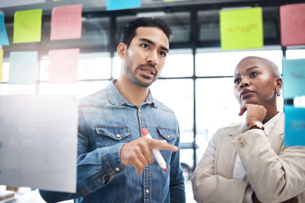 Creative people, team and thinking in schedule planning, brainstorming or meeting at the office. Man and woman in wonder, decision or teamwork for project plan, tasks or sticky note ideas in startup