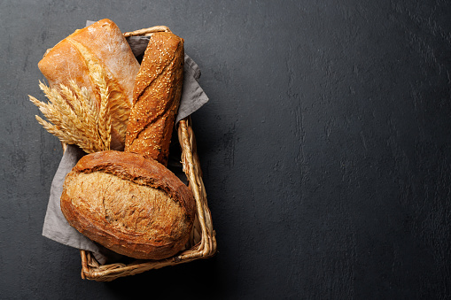 Assorted bread varieties in a charming basket, ready to be enjoyed. Flat lay with copy space