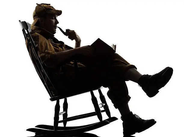 sherlock holmes reading silhouette sitting in rocking chair in studio on white background