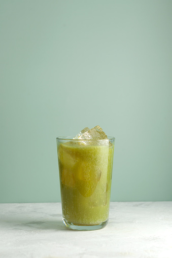 Green herbal smoothie. Glass of fermented detox drink. Natural antioxidant. Iced cold drink.