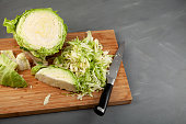 Cabbage head on wooden cutting board. Cutting or chopping fresh cabbage for salad or soup. Cooking from organic vegetables
