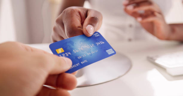 istock Cashier Hand Holding Debit Or Credit Card 1553460527