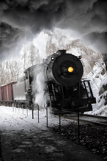 Steam train entering railroad tunnel with black locomotive smoke boiling against ceiling, yellow headlight shining yellow in the darkness.