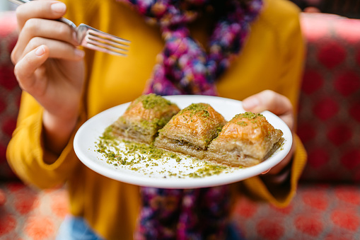 Close-up of a young woman eating Turkish dessert baklava in Istanbul.