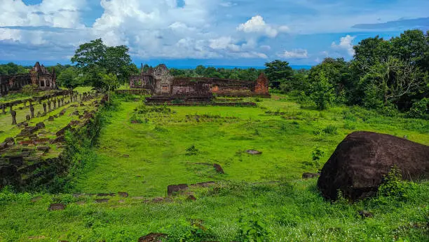 Photo of The beautiful  tree grass and the little white flower slope yard and sanctuary of Wat Phou/vat Phou Hindu /vat Phou Temple complex is the UNESCO world heritage site in Champasak, Southern Laos.