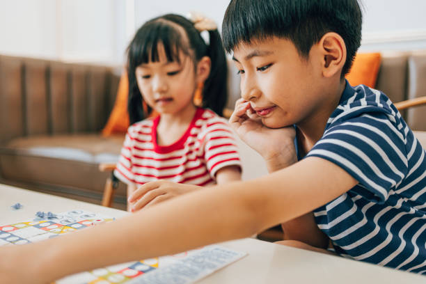 istock Brother and sister play chess 1553484346