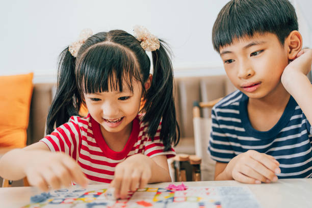 istock Brother and sister play chess 1553484892