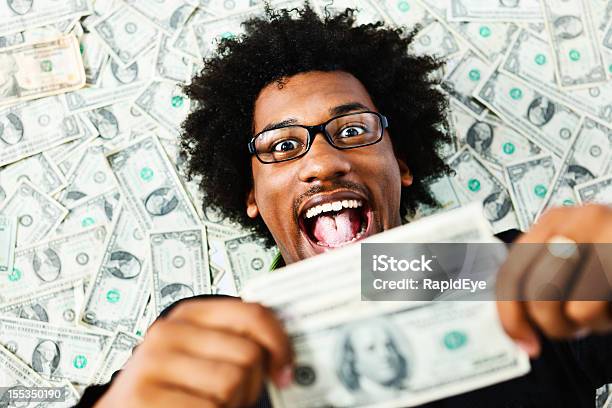 Overjoyed Young Man Surrounded By Us Dollars Stock Photo - Download Image Now - Currency, Happiness, Achievement