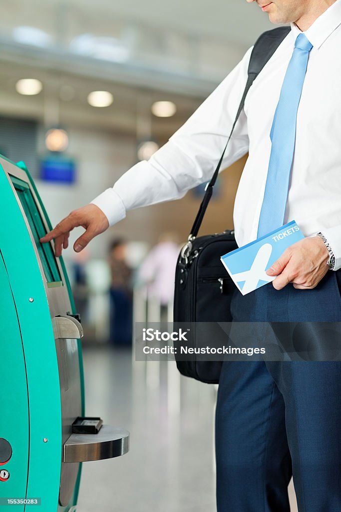 Biznesmen za pomocą zautomatyzowanego urządzenia do odprawy na lotnisku - Zbiór zdjęć royalty-free (30-39 lat)