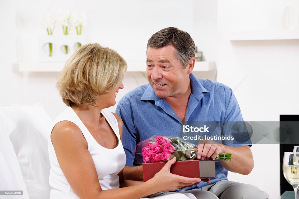 Starszy kobieta otrzymujących Czekolada i kwiaty z partnerem - Zbiór zdjęć royalty-free (Człowiek dojrzały)